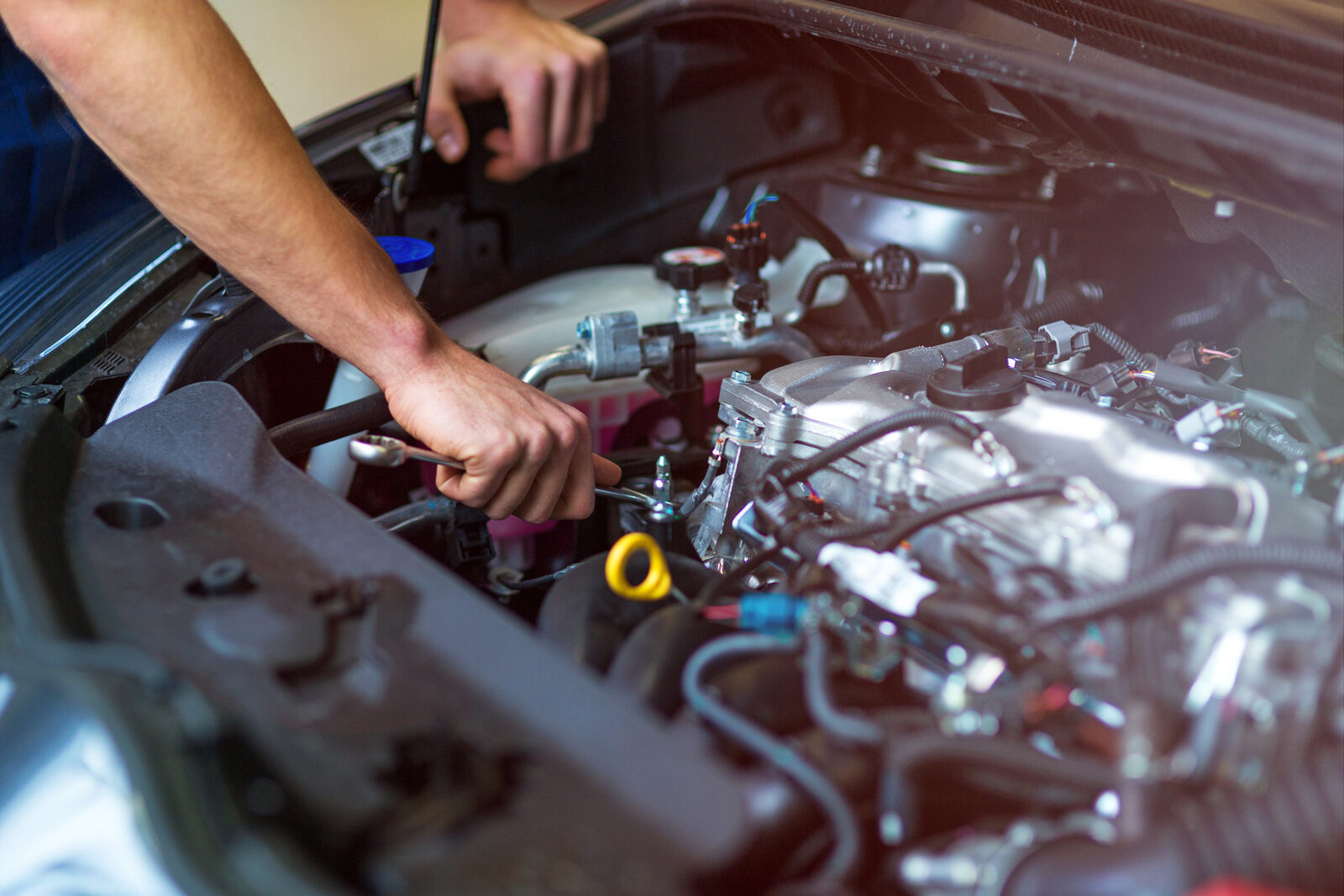 A mechanic's hands repairing a car engine